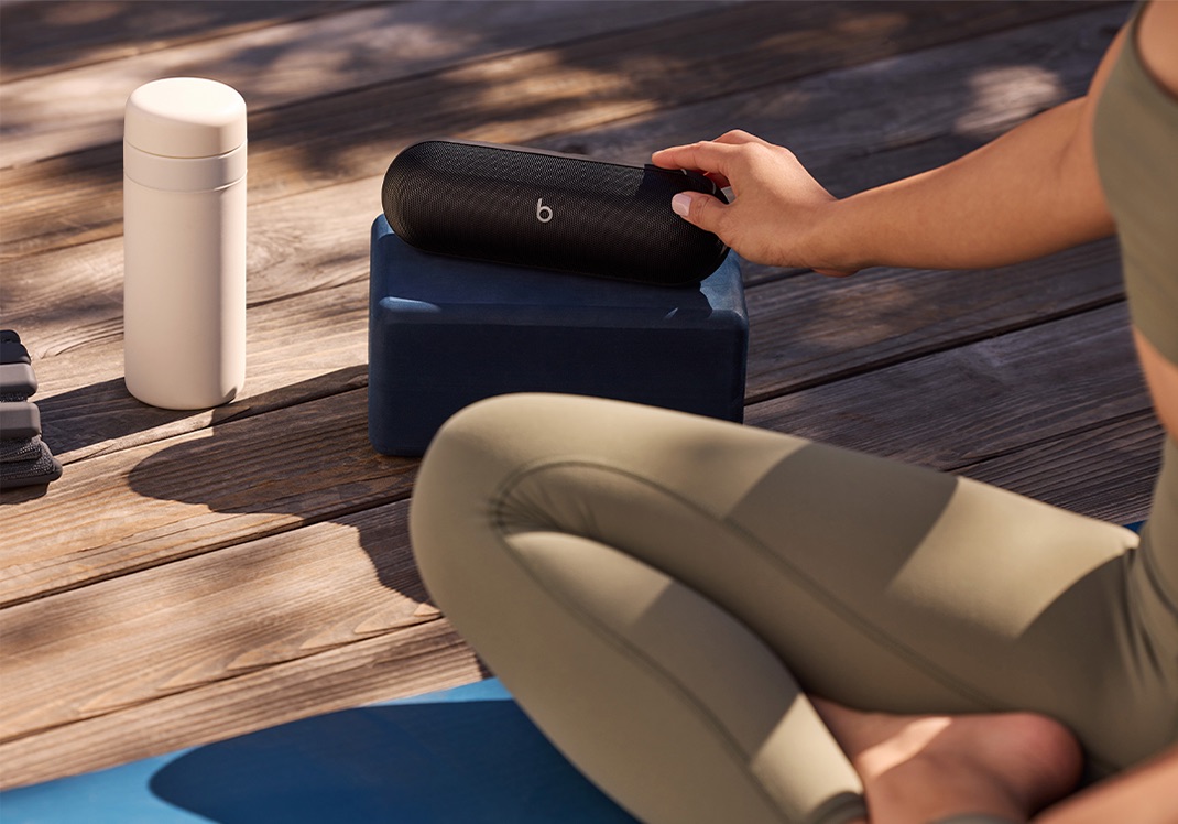 Person holding Beats Pill speaker outdoors