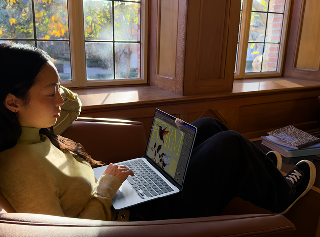 A person sitting in a chair using their „MacBook Air“