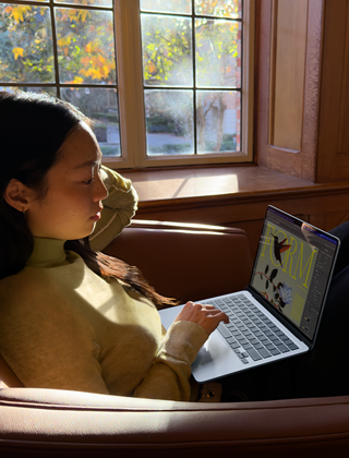 A person sitting in a chair using their „MacBook Air“